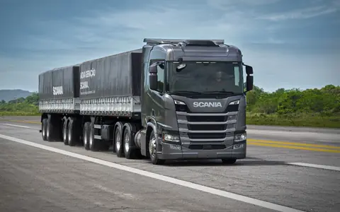 Caminhão Scania com carreta rodando em uma rodovia
